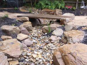 Ornamental dry creek bed with timber bridge